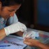 A health worker performs a blood test on children at a malaria clinic in Thailand's Kanchanaburi province. | AFP/Getty Images